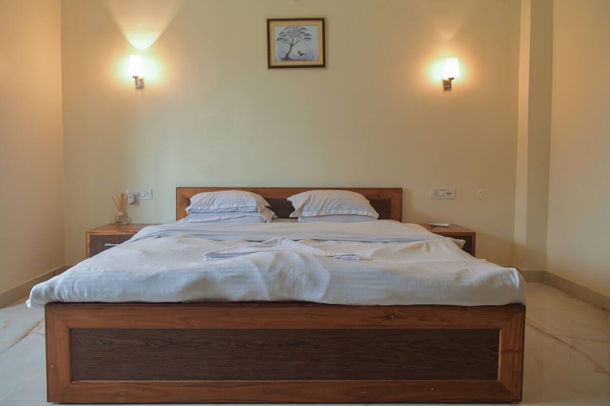 A neatly made bed with a wooden headboard in a hotel room.