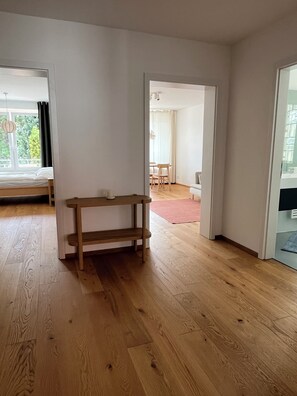 Une pièce comprenant un banc en bois, un coin repas avec des chaises et une vue sur l’extérieur.