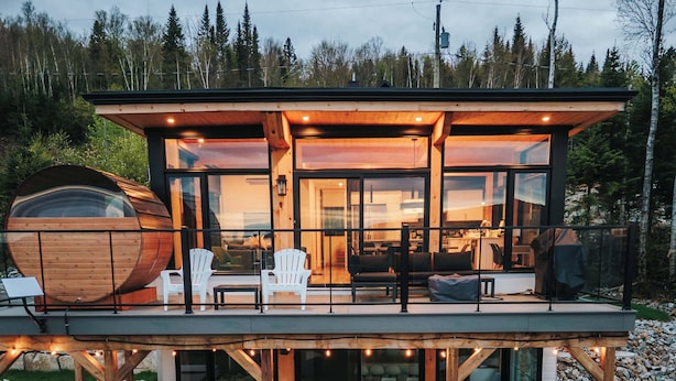 Une maison moderne dotée d’une grande terrasse, d’un espace salon extérieur et d’un jacuzzi.