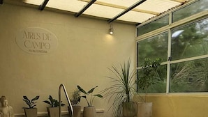 A swimming pool with a clear water surface, surrounded by potted plants and a Buddha statue. - Hosteria Santa Maria (Mercedes)