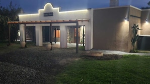 A building with a covered entrance, a sign above it, and a well-maintained lawn. - Hosteria Santa Maria (Mercedes)