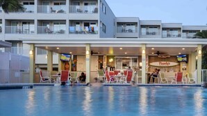A hotel with a pool area, outdoor seating, and a restaurant named Pearly's. - LA Kids Suite | Waterfront w/ Heated Pool Access (Tampa)