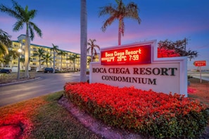 A sign for Boca Ciega Resort Condominium with a digital display showing the temperature and time. - Pets Welcome, Balcony Hot Tub & Pool! (St. Petersburg)