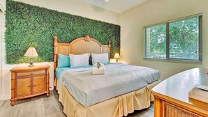 A bedroom with a bed, bedside tables, a ceiling fan, and a window with blinds. - Waterfront Condo w/ Private Balcony & Heated Pool (St. Petersburg)