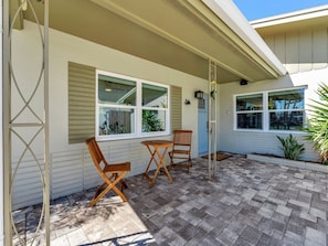 A charming coastal entrance welcomes you to your beach getaway, featuring a private patio with teak bistro seating where you can enjoy morning coffee or evening drinks in the Florida sunshine. - Waterfront heated pool, dock, kayaks and bikes (St. Pete Beach)