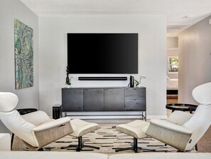 Sink into modern comfort in this sleek living space, where contemporary design meets relaxation. Two white leather lounge chairs invite you to unwind, while the clean lines and minimalist aesthetic create a perfect escape. - Waterfront heated pool, dock, kayaks and bikes (St. Pete Beach)