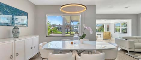 Gather around this elegant dining area where your group can share meals under a modern chandelier. Fresh orchids set a welcoming tone, and the open layout flows seamlessly into your comfortable living space.