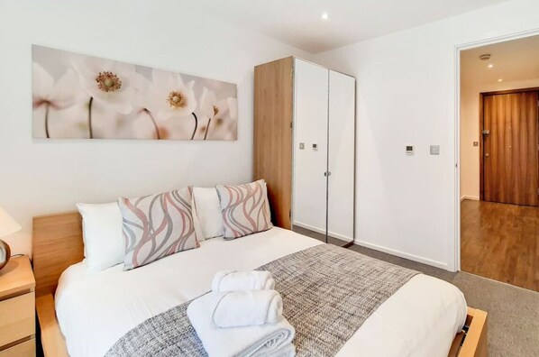 2 habitaciones, escritorio y tabla de planchar con plancha