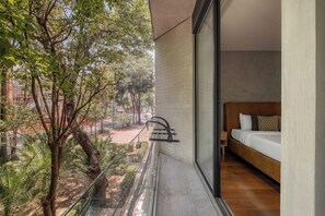 A balcony with a view of trees and a building in the background.