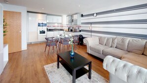 Una sala moderna con un sofá, una mesa de centro y un comedor con sillas y una mesa.