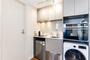 Een compacte keuken met een vaatwasser, een wasmachine en een inbouwoven.