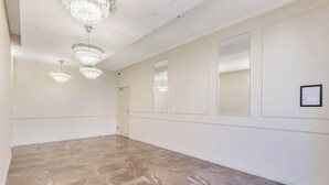 A spacious room with marble flooring, large windows, and three chandeliers. - 1BR Studio in Te Aro - City Lookout (Wellington)