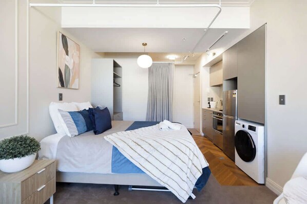 A modern bedroom with a bed, bedside table, and a large window.