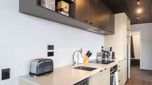 A modern kitchen with a toaster, sink, and coffee maker.