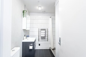 A modern bathroom with a toilet, sink, and shower.