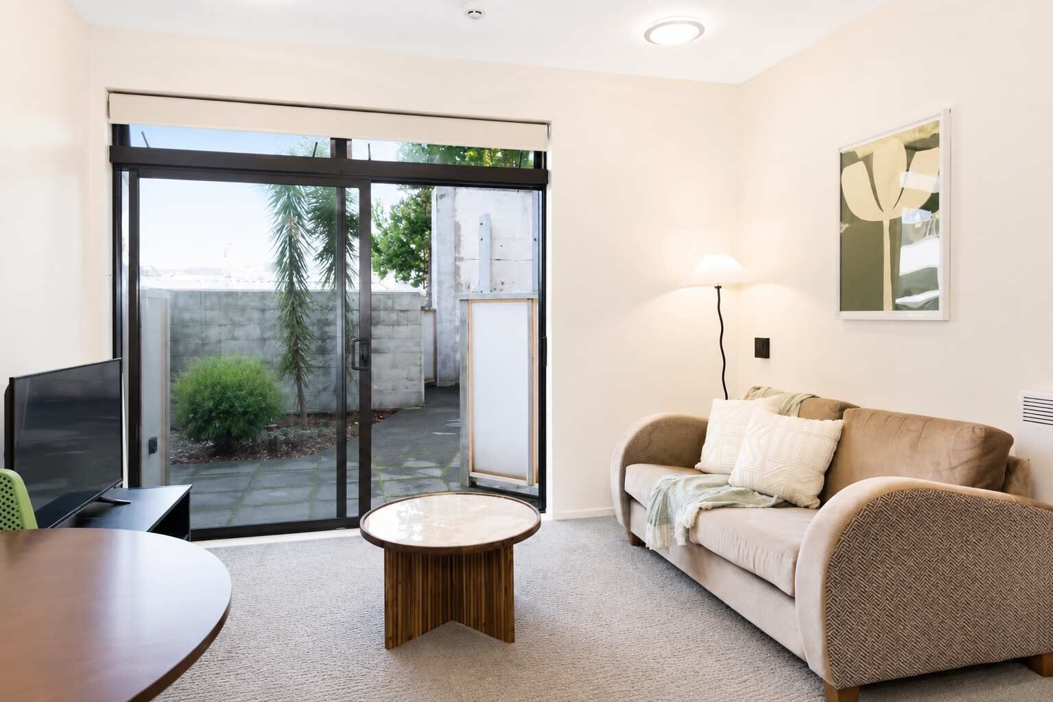 A modern living room with a sofa, a coffee table, and a TV.