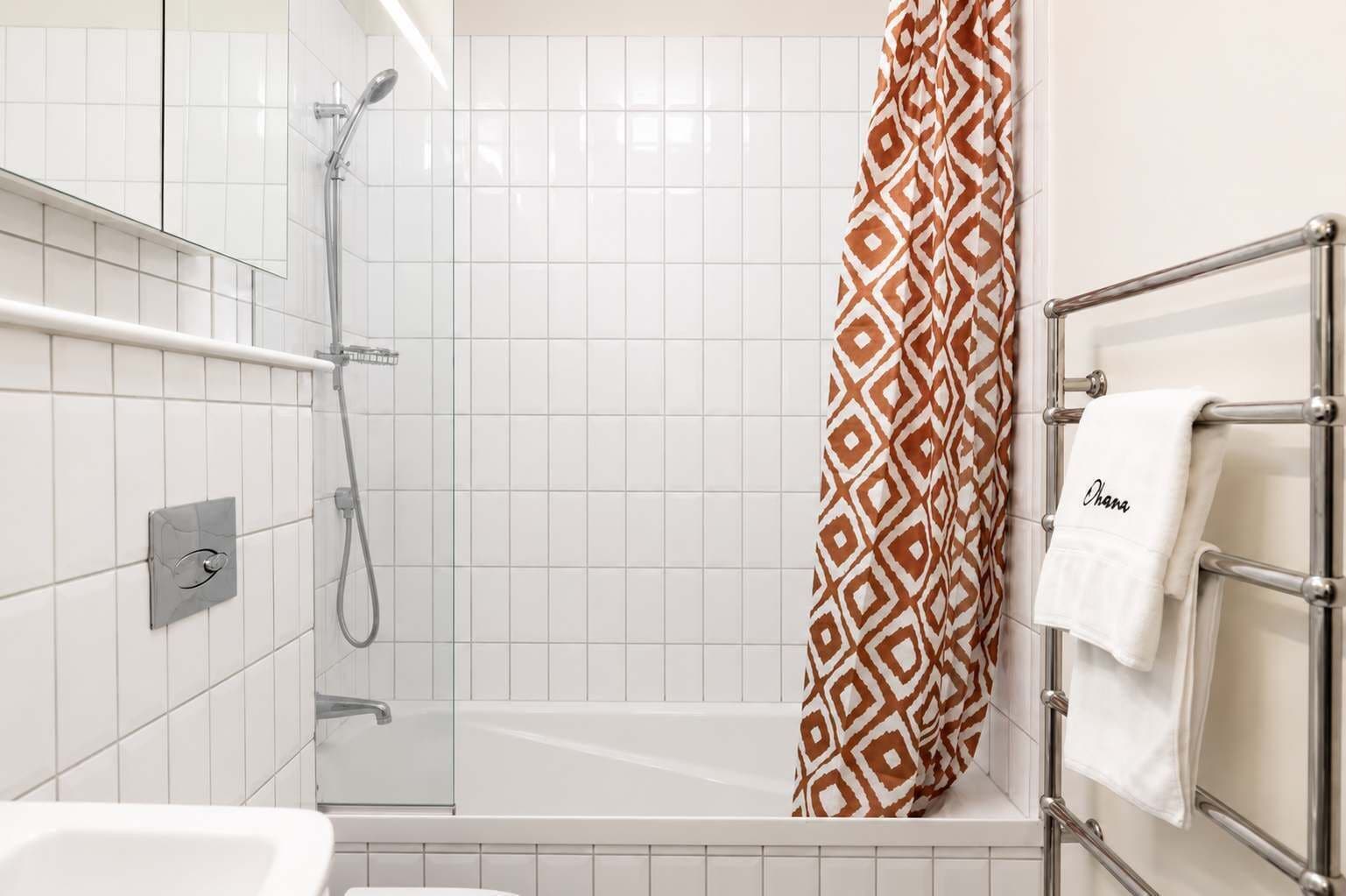 Une salle de bain moderne équipée d’une douche, d’une baignoire et d’un porte-serviettes avec une serviette.