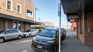 A street view with parked cars, a building labeled 'The Speights Ale House,' and a sign for 'Sals Authentic Pizza.' - Petone Studio Stay | Balcony + Bath and Tub (Lower Hutt)