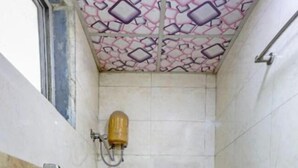 Un baño pequeño con inodoro, ducha y ventana.