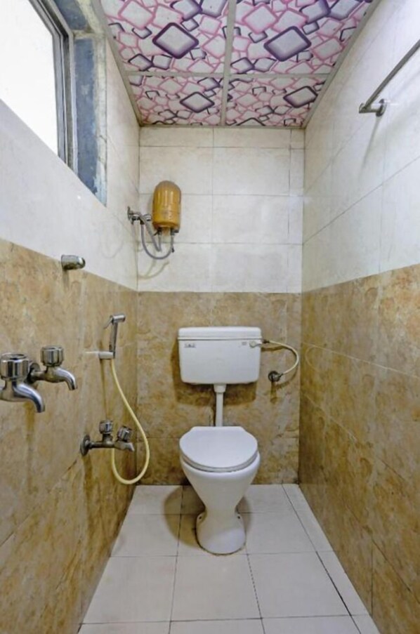 Un baño pequeño con inodoro, ducha y ventana.