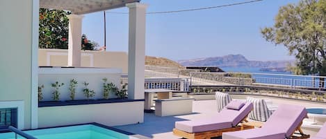 Un espace piscine aménagé sur le toit, avec des chaises longues et une pergola offrant une vue panoramique sur un paysage magnifique.