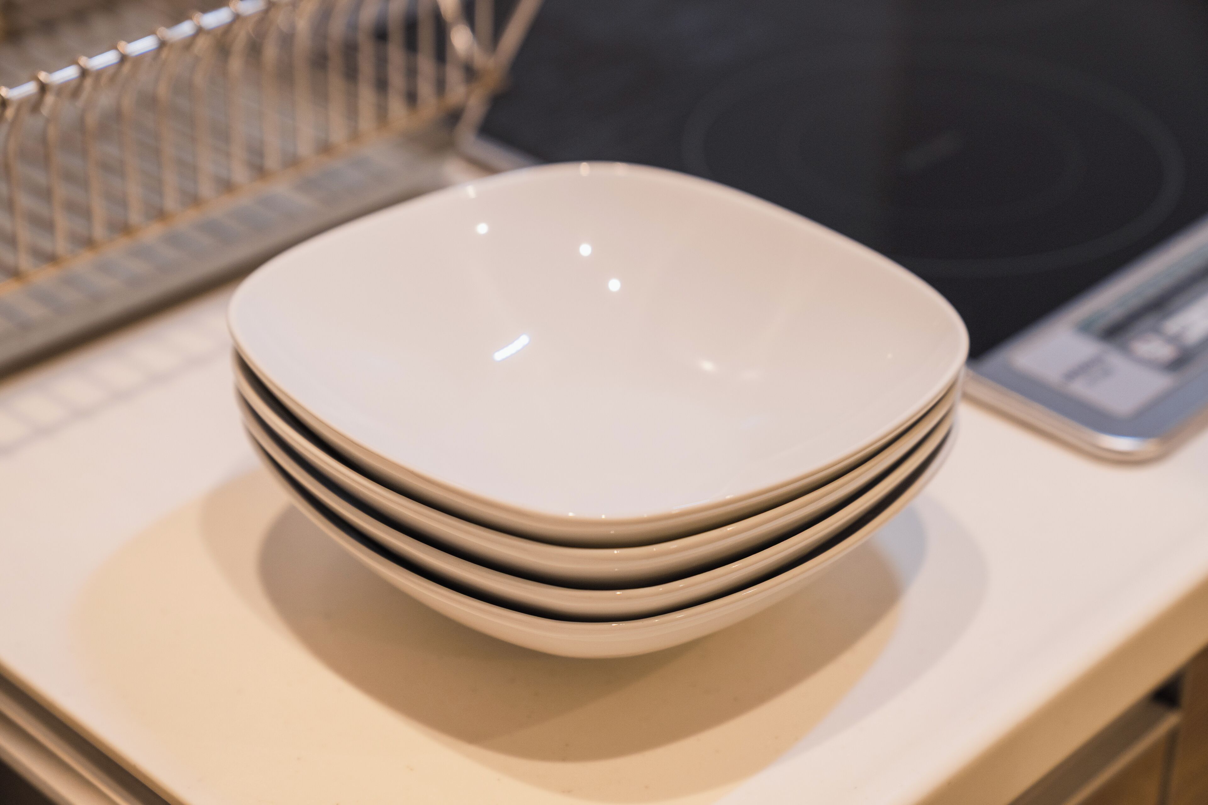 A stack of white plates on a countertop.