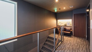 Un intérieur moderne avec un escalier, un canapé en cuir et une porte en bois.