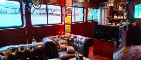 A cozy interior with leather sofas, a small table, and a bar area with a TV.