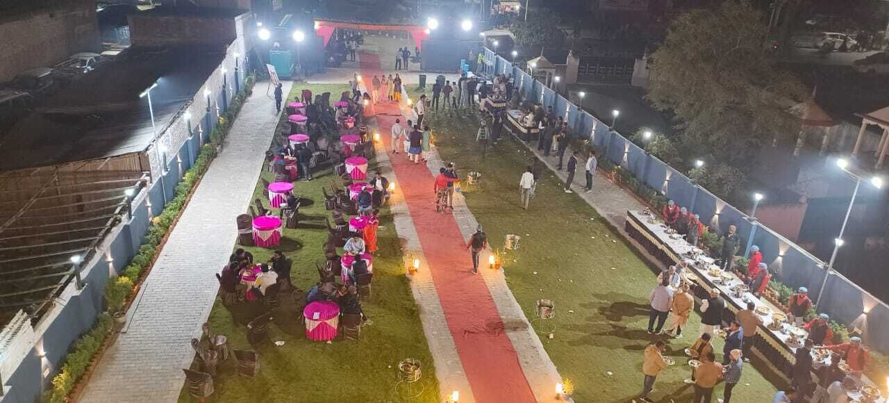 A well-lit outdoor event with a red carpet, tables, and chairs arranged for guests.