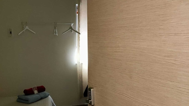 A room with a bed, a wall-mounted air conditioner, a door with the number 3, and a towel rack with hangers. - CTA Catania Aeroporto Fontanarossa (Catania)