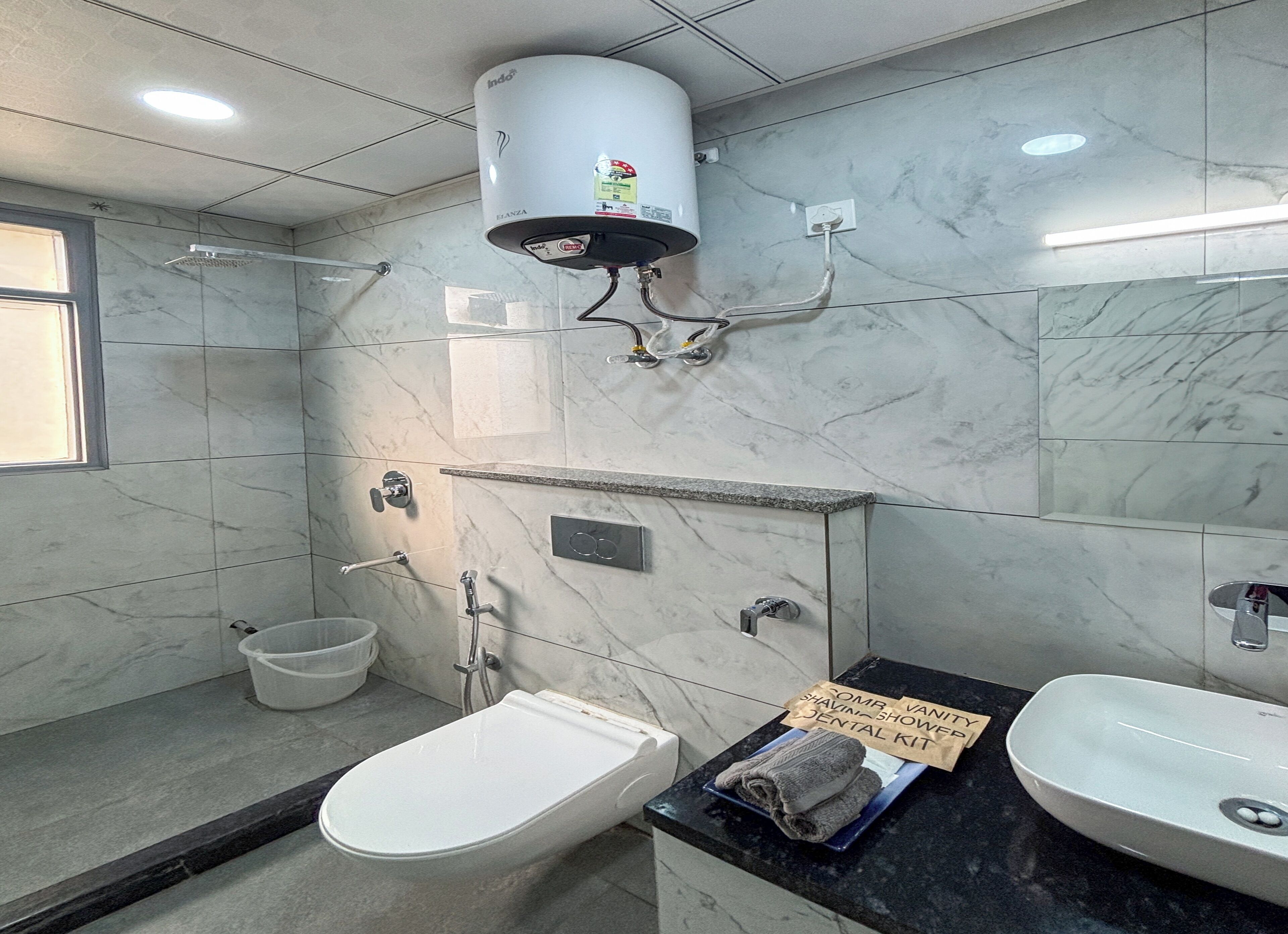 A bathroom with a toilet, sink, shower, and a towel rack.