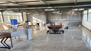 Un'ampia area interna, ben illuminata, con pavimento in granito lucidato, diversi posti a sedere e ampie finestre che lasciano entrare la luce naturale.