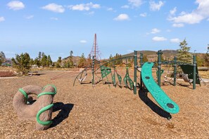 A playground with various equipment such as swings and climbing structures. - Top-Floor Condo Steps from Dillon Amphitheater and Lake Dillon Marina (Dillon)