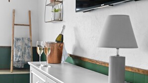 A kitchen counter with a lamp, two glasses, and a bottle of champagne.