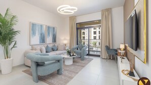 Een moderne woonkamer met een bank, fauteuils en een salontafel. Er is een groot raam met uitzicht op gebouwen en een balkon.