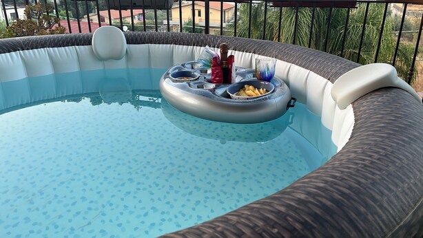A hot tub with a floating platform, surrounded by a pool.