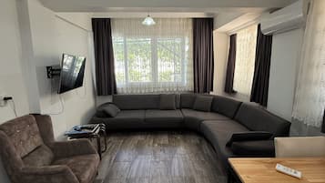 Deluxe kamer, balkon, uitzicht op tuin | Woonruimte | Een 53-inch lcd-televisie met satellietzenders