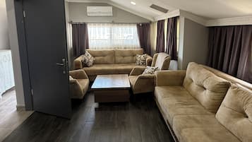 Suite Deluxe, balcon, vue mer | Coin séjour | Télévision LCD de 53 pouces avec chaînes par satellite