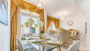 A dining area with a glass table set for four, surrounded by chairs. - Community and Pool View 3BR Townhouse, Minutes from Desert Camp,DAMAC Hills 2 (Dubai)