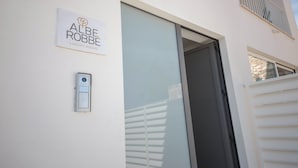 Een gebouwtoegang met een bord waarop staat 'ALBE ROBBE LUXURY ROOMS'.