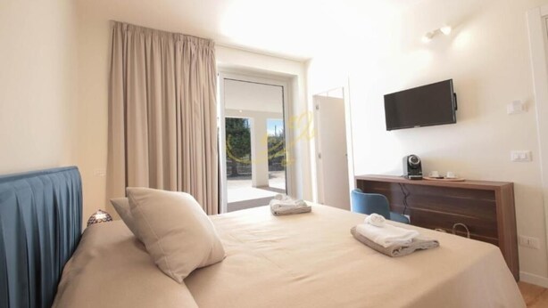Una habitación de hotel con cama, escritorio, televisión y vistas al exterior.
