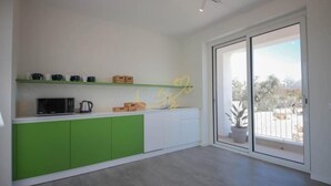 Una cocina moderna con armarios verdes, microondas y cafetera.