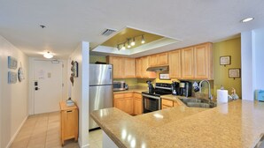Una cocina moderna con armarios de madera, electrodomésticos de acero inoxidable y encimera de granito.