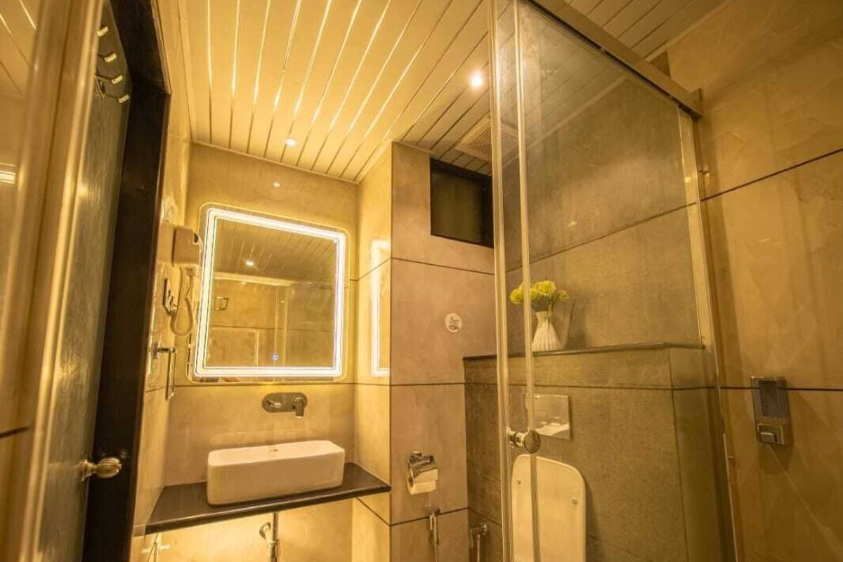 Un baño moderno con ducha de vidrio, inodoro independiente y tocador con espejo.