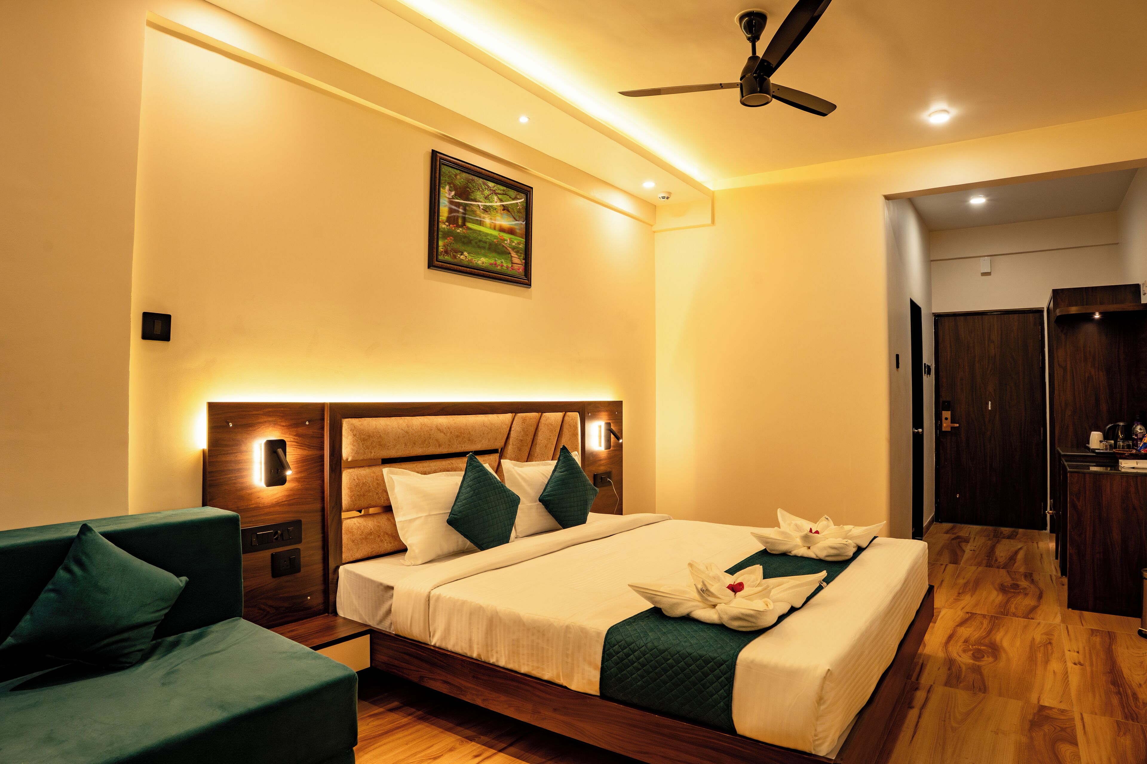 Une chambre d’hôtel équipée d’un lit, d’un bureau, d’une chaise et d’un ventilateur de plafond.