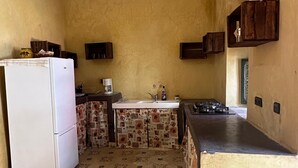 A kitchen with a refrigerator, sink, patterned tiles, wooden cabinets, and a ceiling light fixture. - RIAD Beautiful Places  (Tahannaout)