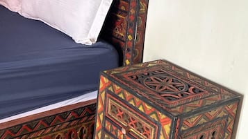 Un lit doté d’une tête de lit à motifs et d’une petite table de chevet au design élaboré.