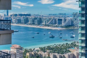 Eine Küstenstadt mit Hochhäusern, einem Yachthafen mit Booten und einem Strand.