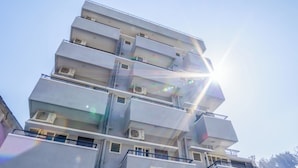 Un immeuble à plusieurs étages doté de balcons et de climatiseurs.
