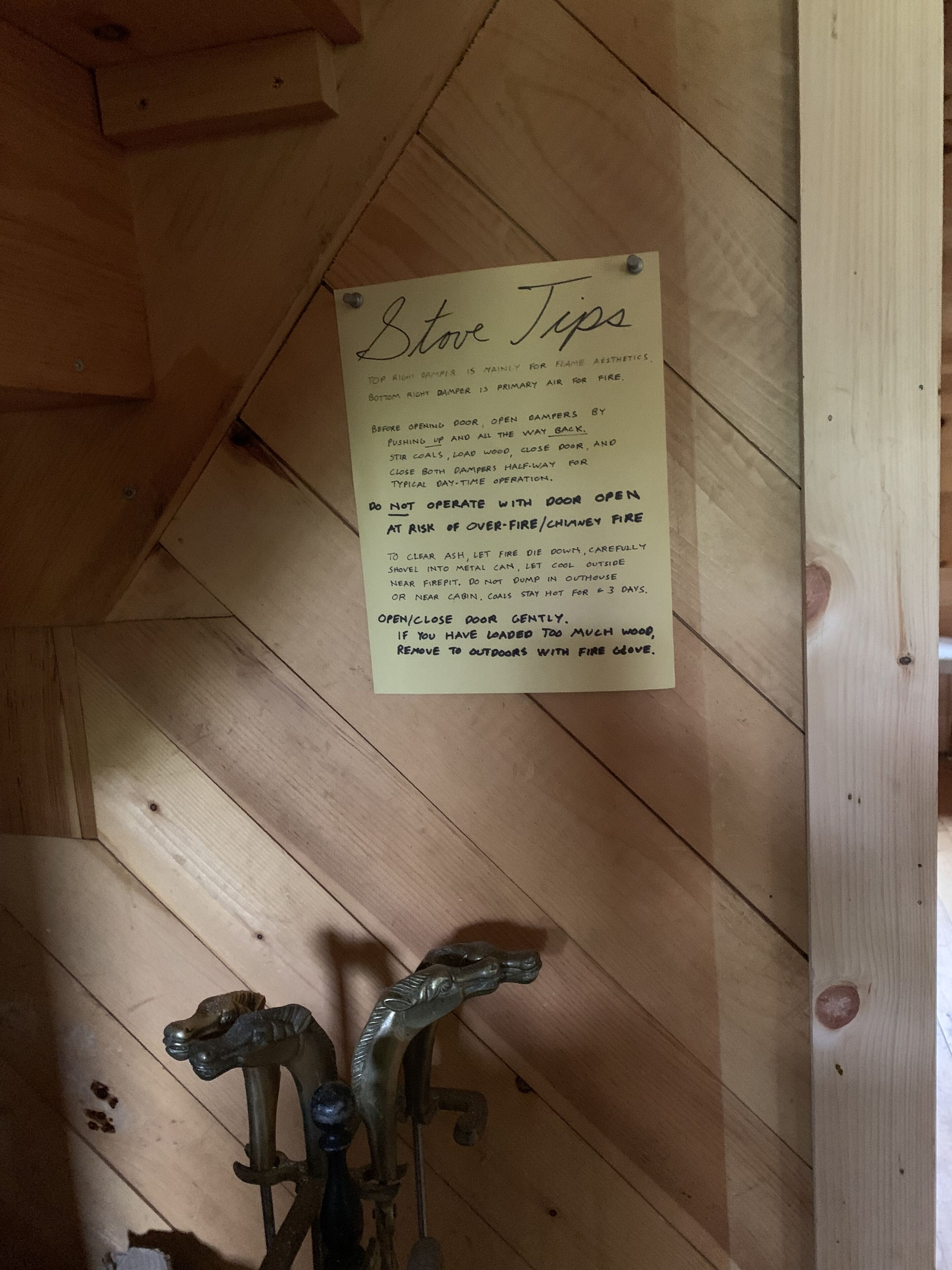Interior de madera con un cartel que ofrece consejos para usar la estufa.